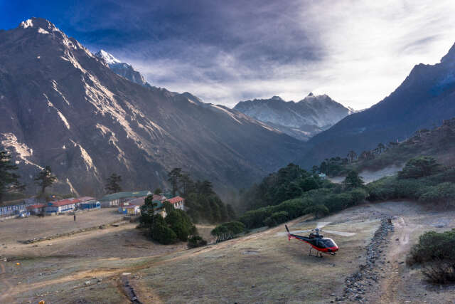 Helicopter Landing In Remote Himalayan Village Surrounded By Mountains In Nepal